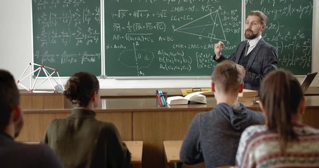 Handsome teacher explaining math lesson to students in classroom, modern education - Powered by Adobe