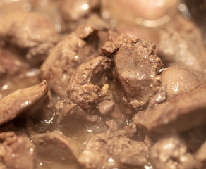 Chicken liver is fried in a pan.