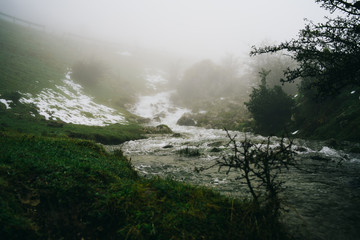 Misty scenery of river during thawing in northen spain
