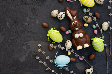 Delicious chocolate easter bunny and eggs on a stone background. Happy easter. Copy space.
