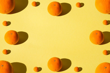 Juicy tasty tangerines. Lots of fruit on bright yellow summer background.