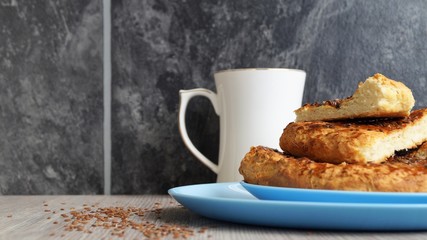 oriental bread on a blue dishwith white porcelain mug and linen seeds on a wooden table on black background