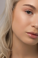 Fototapeta premium Closeup of half beauty woman with clean skin and natural cosmetics. Beautiful extrem eyelash and full lips of well-groomed girl demonstrate spa procedures, injections in a beauty parlor. Blonde hair