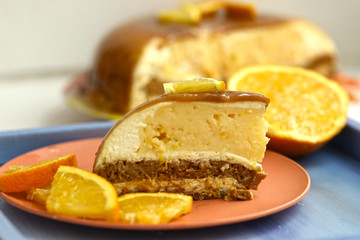 cut orange caramel mousse cake with cream cheese mascapone and chocolate glaze with nuts close up photo