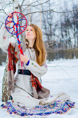 A young blonde woman in traditional Slavic clothing holds the symbol of generations - the Family...
