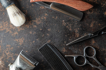 vintage barber tools: dangerous razor, hairdressing scissors, old manual clipper, metal comb, shaving brush.
