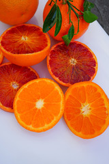 Platter of orange and mandarosa red clementines cut in half on a white platter