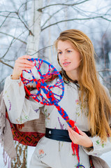 A young blonde woman in traditional Slavic clothing holds the symbol of generations - the Family...