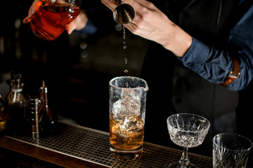 Bartender adds one of the ingredients for a cocktail