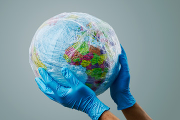 doctor with a world globe wrapped in plastic.