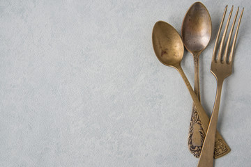 Table setting in vintage style. Antique fork, knife, spoon on old light  background. Space for text, flat lay