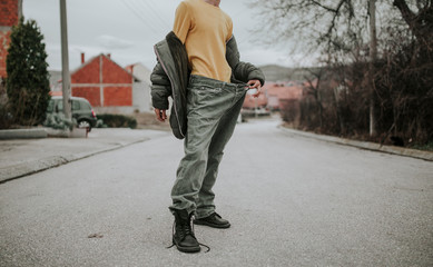 Teenager posing on the streets in baggy jeans, stylish outfit