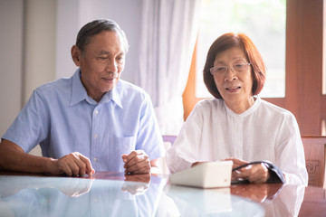 Asian retired couple operate home blood pressure monitoring