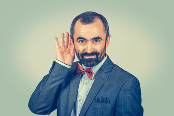 Curious nosy man with hand to ear listening to gossip