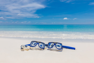 Diving goggles and snorkel gear on white sand near beach. Summer vacation and recreational travel...