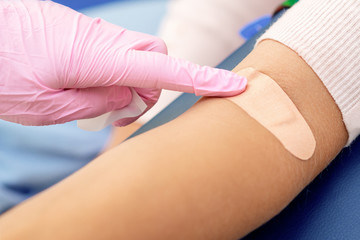 Doctor glues an adhesive bandage.