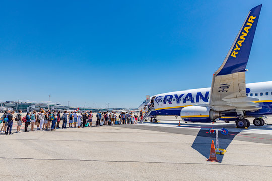 October 19, 2019: Passengers boarding Ryanair flight from Santiago Spain to Milano Italy on a sunny day. Ryanair is biggest budget low-cost airline in the world. (no recognizable faces) 