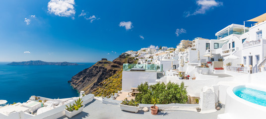 Beautiful panoramic landscape of Santorini island, Oia luxury resort and blue sea sea view with white architecture. Famous travel destination, amazing scenery with pools and luxurious Europe tourism - obrazy, fototapety, plakaty