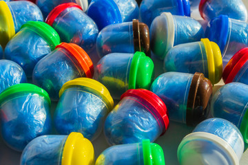 Blue shoe covers in individual capsules with multi-colored caps. Disposable shoe covers. Protection concept.