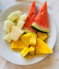 on the table in a plate are pieces of fruit