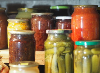 The benefits and harms of canned products. Domestic blanks in banks in the basement are arranged in a row on shelves for storage.