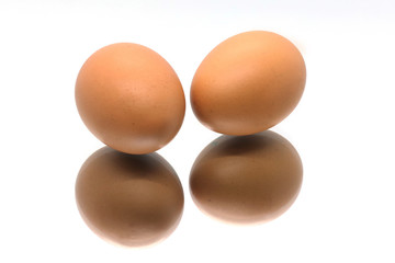 Two boiled eggs isolated on a white background with reflection.