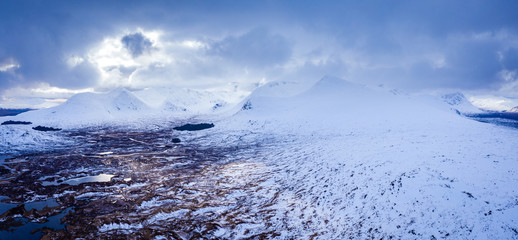 aerial drone shot of rannoch moor and the entrance to glencoe in winter with Lochan na h-Achlaise during march