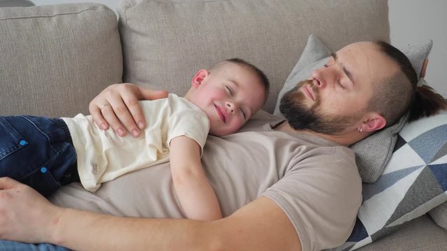 Small boy sleeping on father chest real life authentic father and son bond