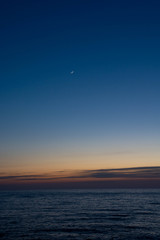 静かな海の夕暮れと三日月