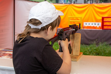 a boy with a machine gun in a shooting range shoots at a target