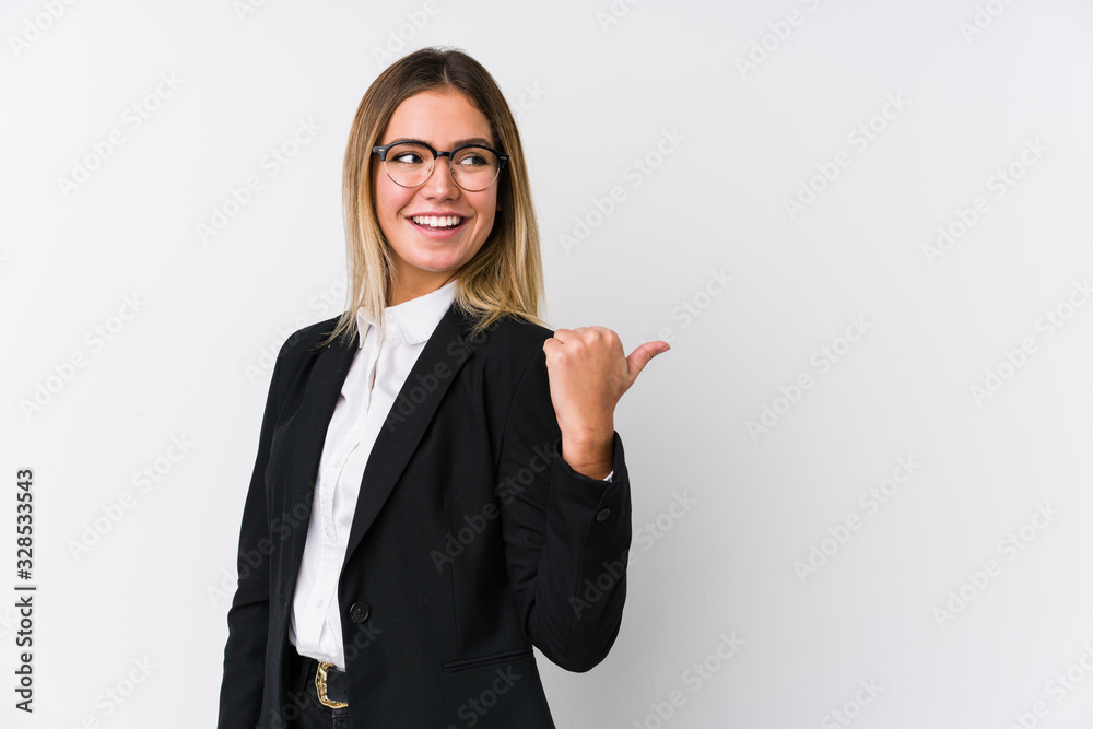 Wall mural young business caucasian woman points with thumb finger away, laughing and carefree.