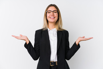 Young business caucasian woman makes scale with arms, feels happy and confident.