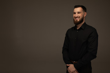 Obraz premium Handsome business man smiling at the camera on grey background.