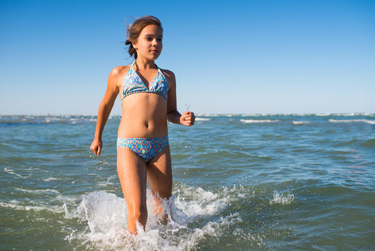 Portrait of a joyful little girl swimming in sea