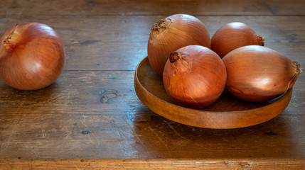 onions in wooden bowl on old table