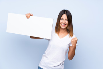 Young woman over isolated blue background holding an empty white placard for insert a concept
