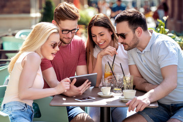 Cheerful group of friends having fun in cafe