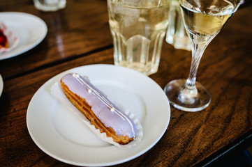 Traditional french Eclairs with original decor on a brown background table.