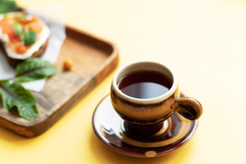 Breakfast with a cup of tea or coffee with sandwiches. Cheerful beginning of the day. Morning pleasure, harmony and pleasure
