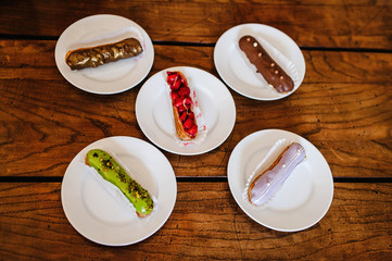 Traditional french Eclairs with original decor on a brown background table. Top view.