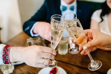 Celebration. Hands holding the glasses of champagne and wine making a toast. The party, alcohol, lifestyle, friendship, holiday, christmas, new year, wedding and clinking concept.