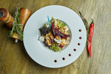 Nutritious and healthy salad with baked beets, lettuce, feta cheese, walnuts in a white plate. Vegetarian dish. Top view with copy space