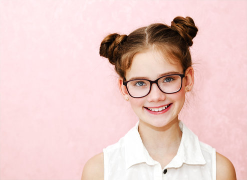 Portrait of funny smiling little girl child wearing glasses isolated