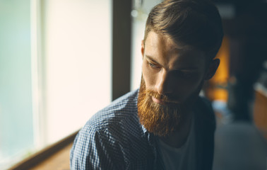 Close-up portrait of a brutal bearded man Portrait of a handsome bearded man looking away indoors Copy free space