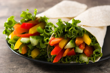 Vegetable tortilla wraps on wooden table