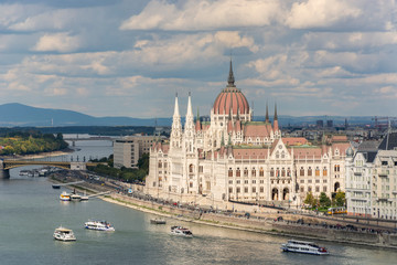 Obraz premium The hungarian Parliament in Budapest. Danube river. Cloudy sky.