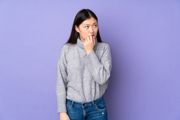 Young asian woman over isolated background nervous and scared