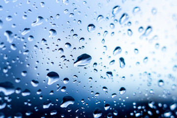 Raindrops close up on wet glass in the afternoon_