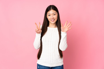 Young asian woman over isolated background counting seven with fingers