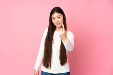 Young asian woman over isolated background doing coming gesture